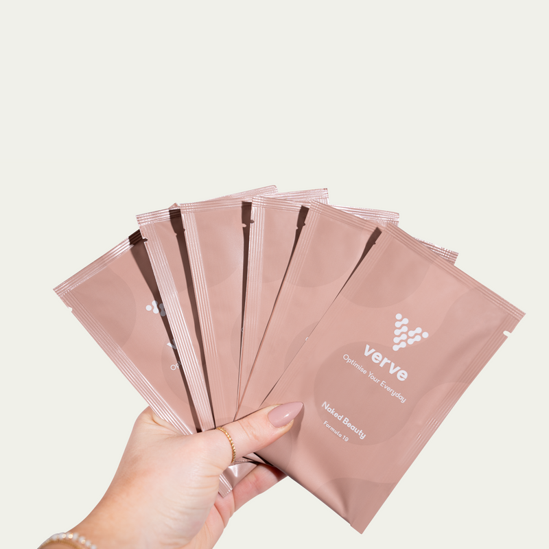 Person holding seven pink Verve sachets labelled “Naked Beauty – Formula 19”.