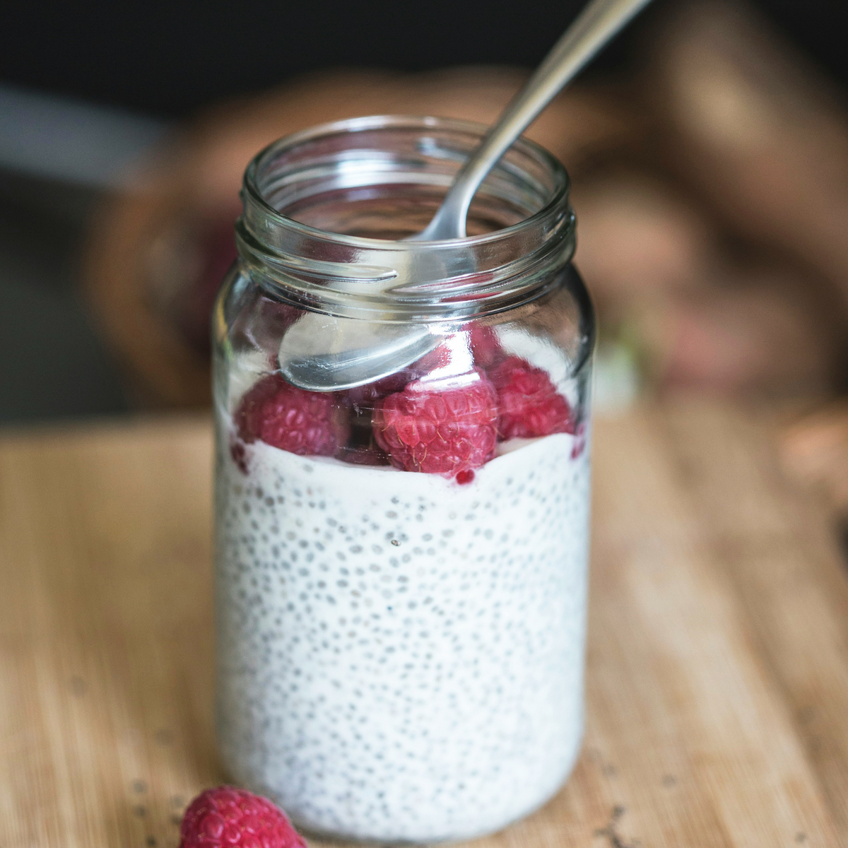Chia seed pudding in a glass jar topped with raspberries