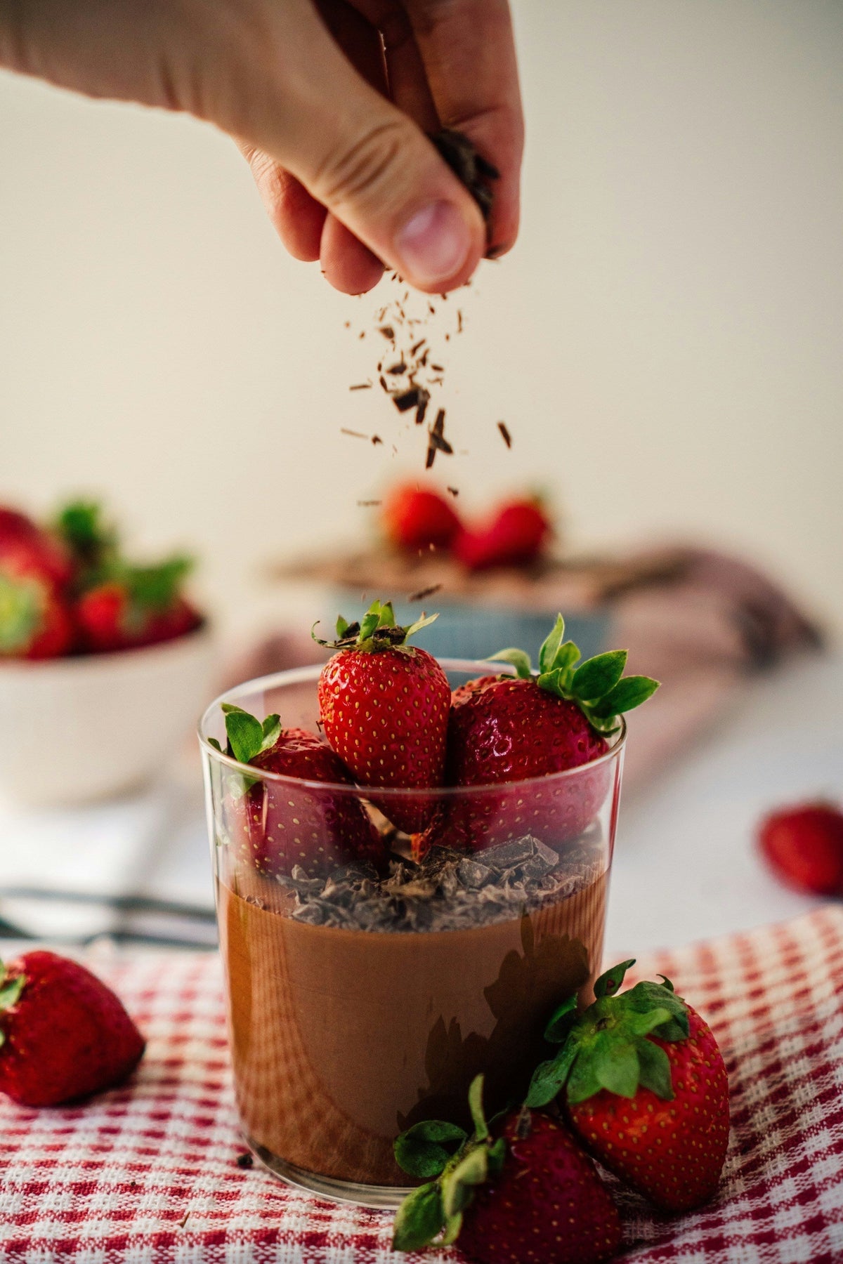 Chocolate mousse in a glass topped with strawberries and chocolate shavings