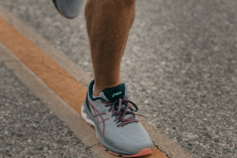 A runner's legs and trainers on a running track
