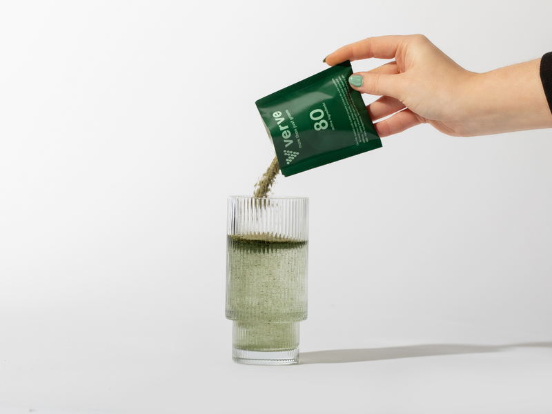 Verve Greens powder pouring into glass from sachet