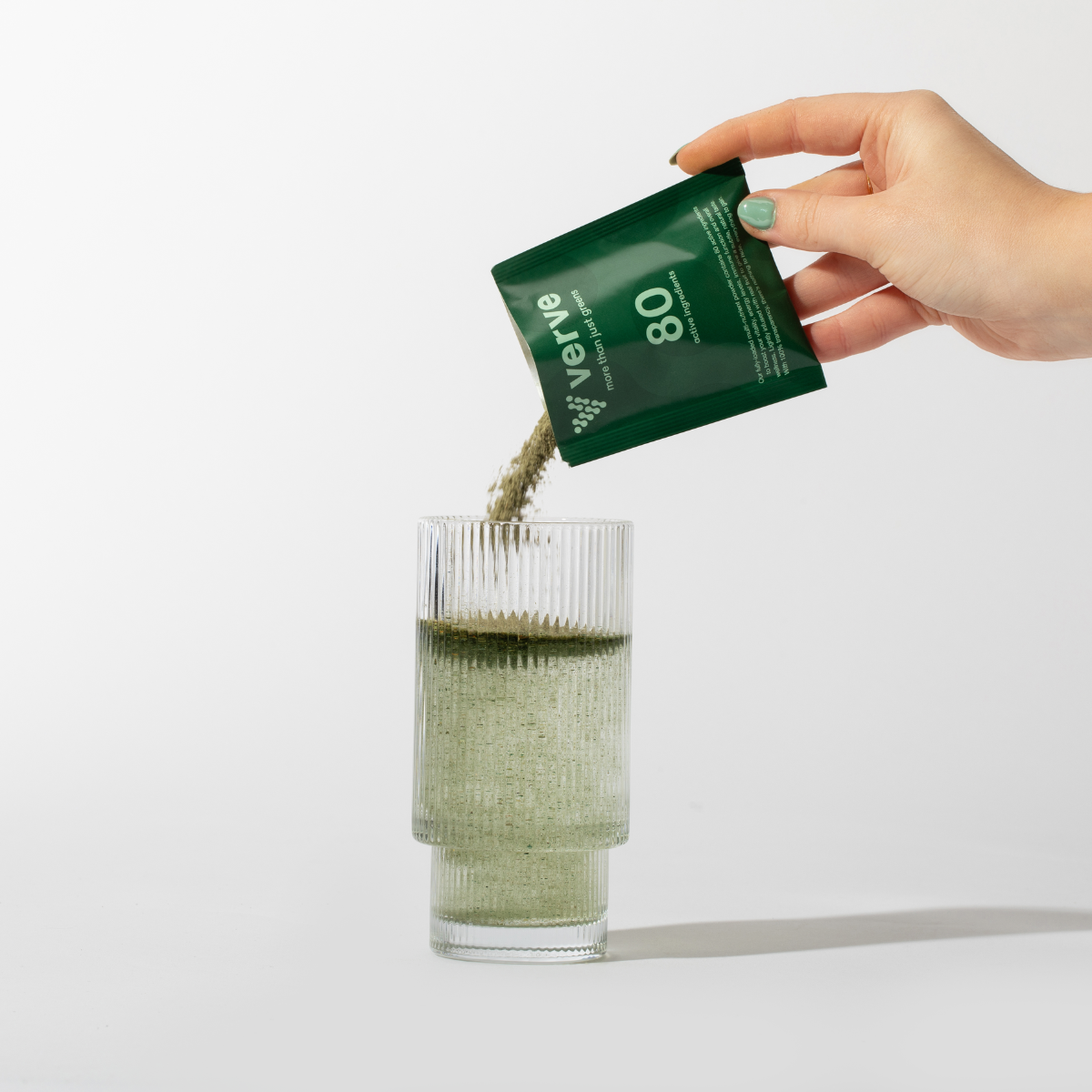 Verve Greens powder pouring into glass from sachet